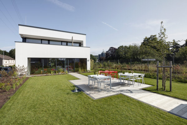 Rasenfläche und Terrasse direkt vor dem großen Seminarraum, der durch eine Tür mit dem Garten verbunden ist. 